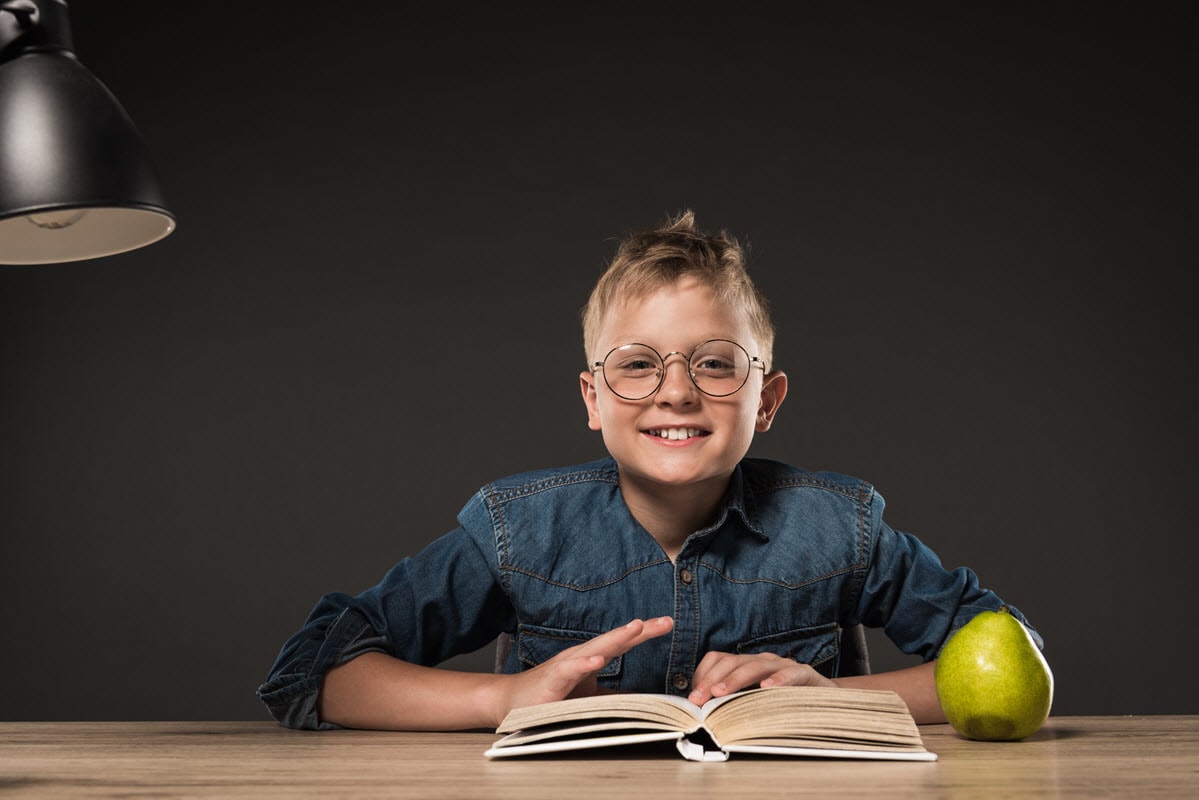 The featured image for the sight words vs phonics blog post showing a young boy sitting at his desk, reading