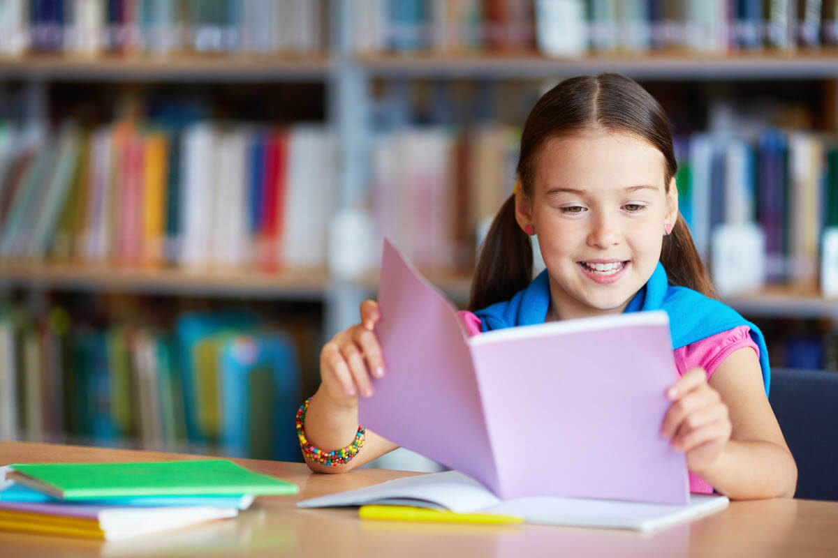 why is phonological awareness important featured image showing a girl sitting in the library and reading
