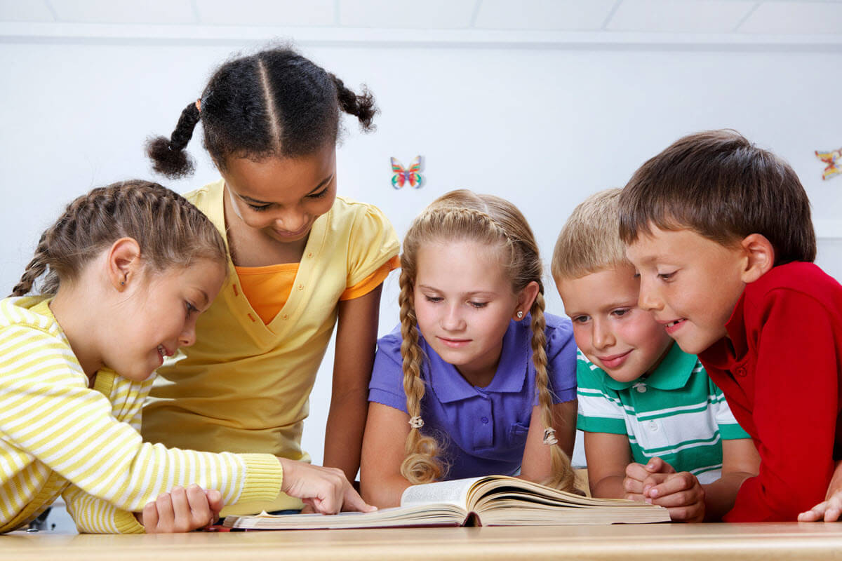 Activities to teach phonemic awareness featured image of 5 grade school kids gathered around a book