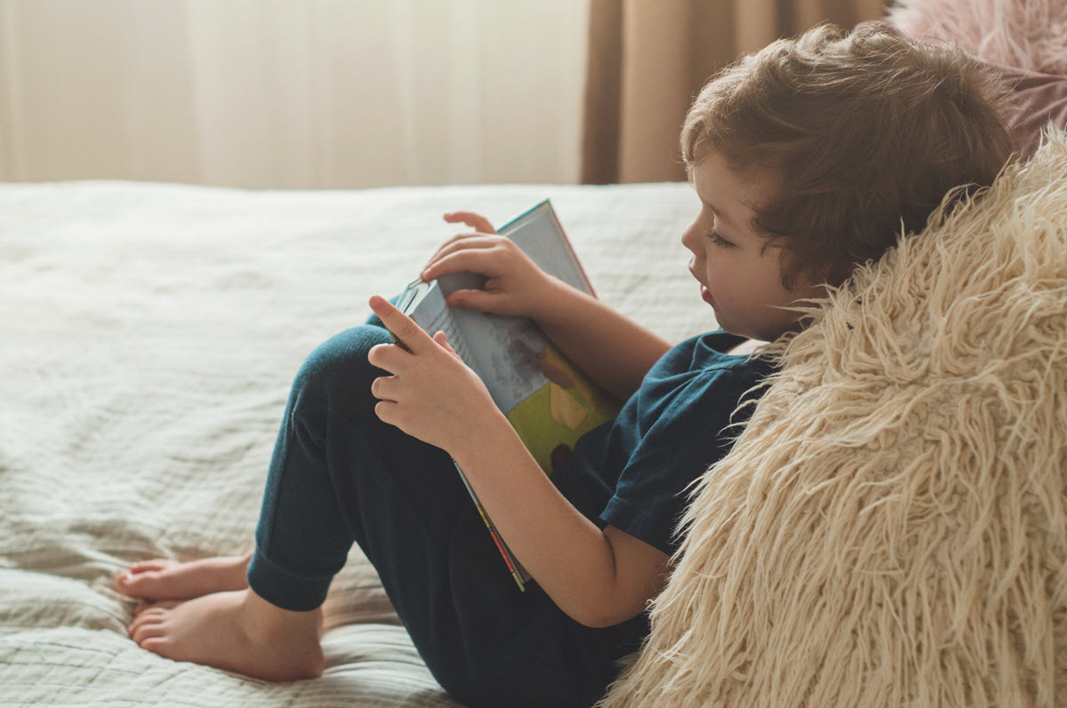 Sound boxes for phonics featured image of a boy laying on his bed while reading